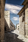 Calle estrecha de Pedraza entre casas de piedra y vista al fondo.