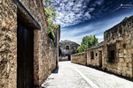 Calle clara de Pedraza entre fachadas y muros de piedra.