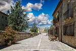 Calle amplia de Pedraza con casas de piedra y cielo azul.