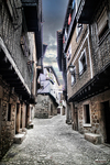 Calle estrecha de La Alberca entre casas antiguas de madera y piedra.