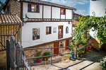 Casa blanca y de piedra en Mogarraz con escaleras, balcones y retrato mural.