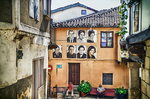 Fachada de Mogarraz con retratos pintados, flores y arquitectura popular.