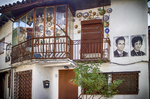 Casa de Mogarraz con balcones de madera y retratos pintados en la fachada.