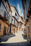 Calle luminosa de Mogarraz con casas tradicionales de piedra y madera.