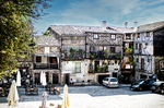 Plaza de Mogarraz con casas serranas, coches y arquitectura popular.