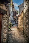 Callejón estrecho de Mogarraz entre muros de piedra y casas antiguas.