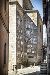 Calle empinada de Mogarraz con fachadas de piedra y luz de mediodía.