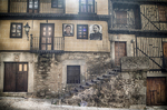 Casa antigua de Mogarraz con balcones cerrados de madera y muros de piedra.