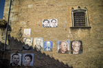 Muro de piedra en Mogarraz con retratos pintados sobre la fachada.