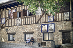 Fachada de Mogarraz con entramado de madera, piedra y retratos pintados.