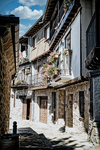 Calle de Mogarraz con casas tradicionales de piedra, madera y luz de pueblo serrano.