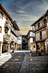 Calle de Sequeros con casas de piedra y madera en una pequeña plaza.