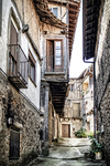 Calle estrecha de Sequeros con balcones de madera y arquitectura popular serrana.