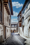 Calle luminosa de Sequeros con casas blancas, balcones y cielo azul intenso.