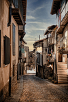 Calle empedrada de Sequeros con casas de piedra y ambiente rural.