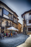 Plazoleta de Sequeros con terraza, sombrilla y casas tradicionales alrededor.