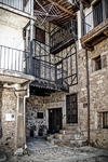 Fachada rústica de Sequeros con balcón, escaleras y estructura de madera.
