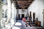 Galería luminosa con arcos, ventanales y mobiliario antiguo en Monforte de Lemos.