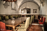 Comedor interior con mesas, sillas rojas y arquitectura antigua en Monforte de Lemos.