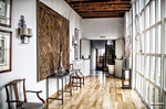 Sala interior con suelo de madera, sillas y grandes ventanales en Monforte de Lemos.