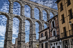 Arcos del Acueducto de Segovia junto a fachadas tradicionales del casco histórico.