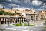 Vista urbana de Segovia con arquitectura histórica y cielo dramático.