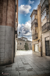Calle silenciosa entre muros de piedra en el centro histórico de Ávila.