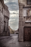 Calle estrecha entre arquitectura medieval y viviendas antiguas en Ávila.