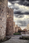 Torreones de la muralla de Ávila bajo un cielo tormentoso.