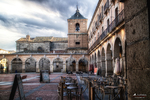 Plaza porticada con iglesia y edificios históricos en Ávila.