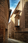 Calle estrecha con arquitectura tradicional del casco antiguo de Toledo.