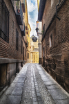 Calle empedrada entre casas históricas del centro de Toledo.