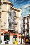 Plaza urbana con edificio tradicional y fachada acristalada en Toledo.
