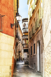 Callejuela de Toledo con fachadas de colores y balcones tradicionales.