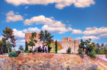 Murallas y torreones de Toledo bajo cielo azul con nubes.