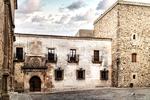 Palacio de piedra con balcón y torre en el casco histórico de Cáceres.