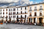 Plaza Mayor de Cáceres con soportales y edificios blancos tradicionales.