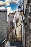 Calle antigua con escalinata y fachadas de piedra en Cáceres.