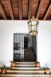 Entrada interior con escalera, farol y puerta enrejada en Cáceres.