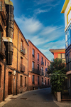 Calle tranquila con edificios de ladrillo y piedra en León.