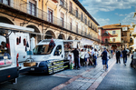 Calle animada con vehículos y edificios clásicos en el centro de León.