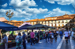 Plaza Mayor de León con mercado y ambiente de gente.