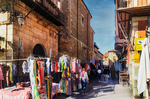 Calle comercial con puestos y edificios antiguos en León.