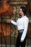 Eva posa junto a una barandilla con camisa blanca, pantalón negro y actitud elegante.
