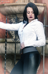 Eva posa de perfil con camisa blanca junto a una barandilla antigua.