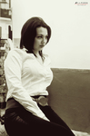 Eva sentada en una fotografía de tonos sepia, con camisa blanca y expresión tranquila.