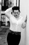Eva posa en blanco y negro con camisa blanca, una mano en la cabeza y gesto teatral.