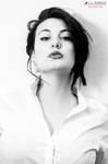 Retrato en blanco y negro de Eva con camisa blanca y gesto intenso.
