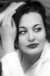 Retrato en blanco y negro de Eva con la mano en el pelo y expresión serena.