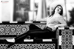 Eva posa en blanco y negro sobre un banco decorado con azulejos.